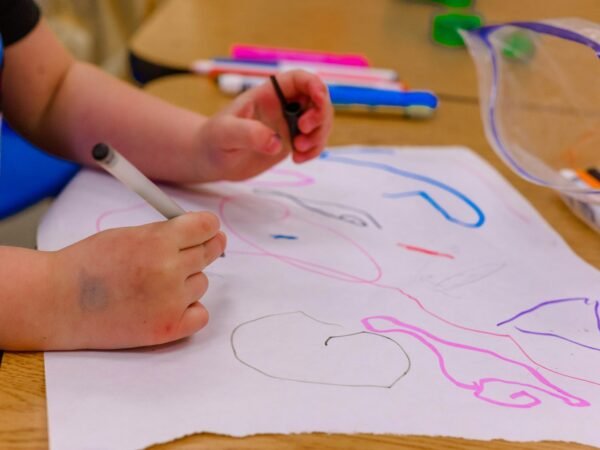 Un enfant concentré qui dessine sur une feuille de papier